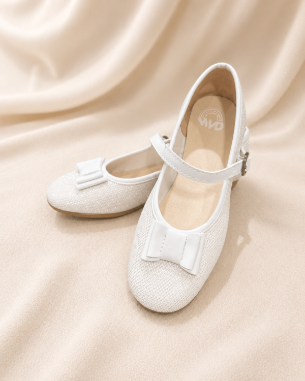 Zapatos con brillo y moño blanco.